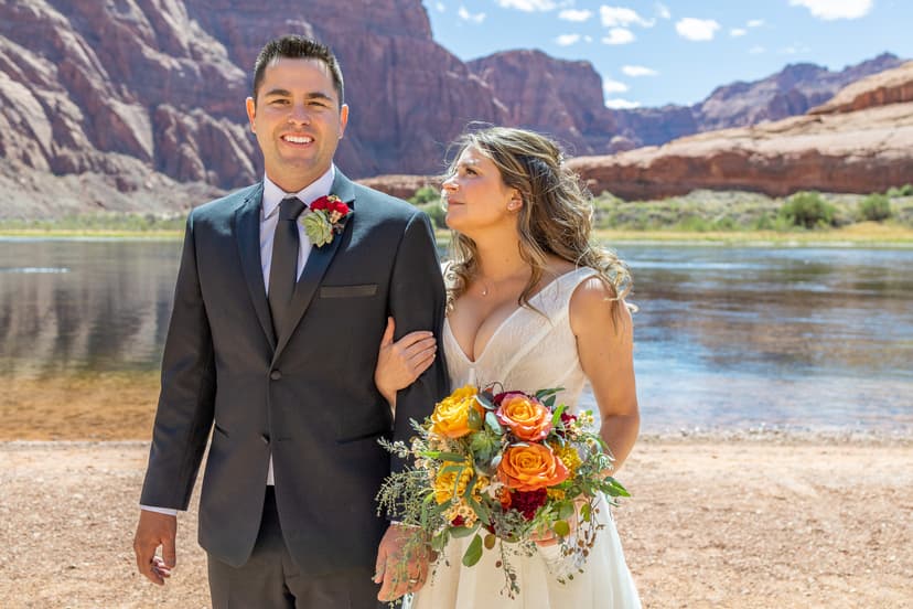 bride and groom in front of river