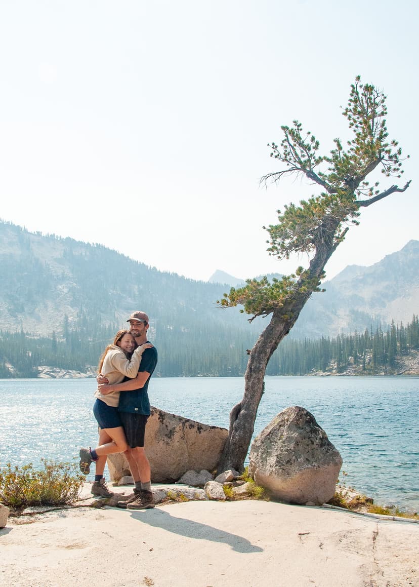 man and woman hugging in front of lake