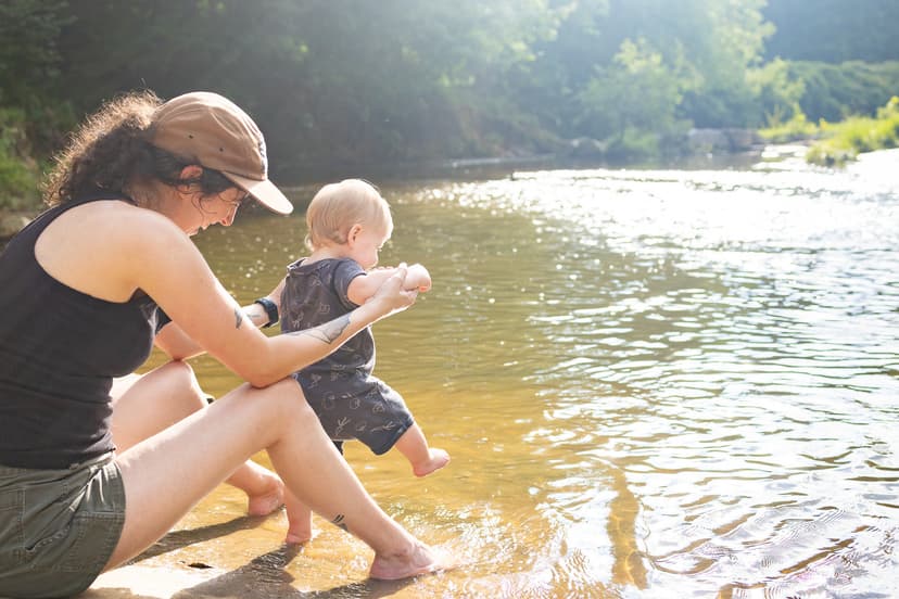 mom and baby playing in river